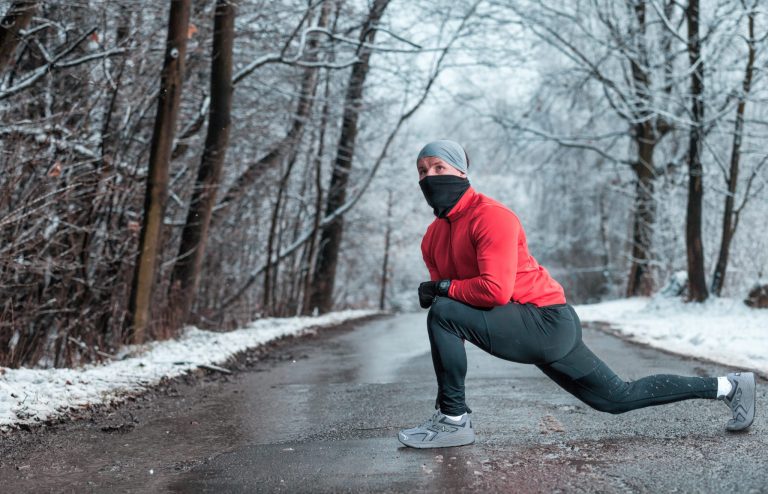 Picture of a man stretching on a trail while wearing Xelero shoes.