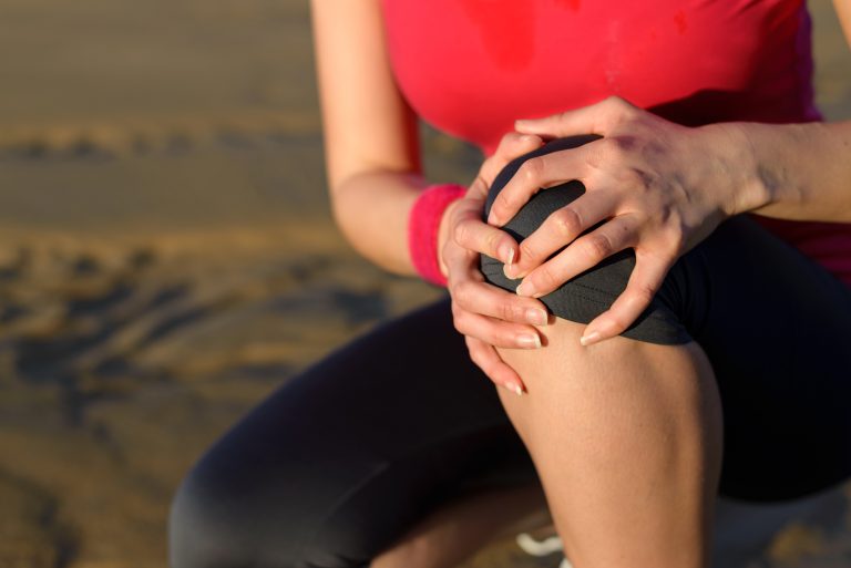 Runner sitting down with knee injury